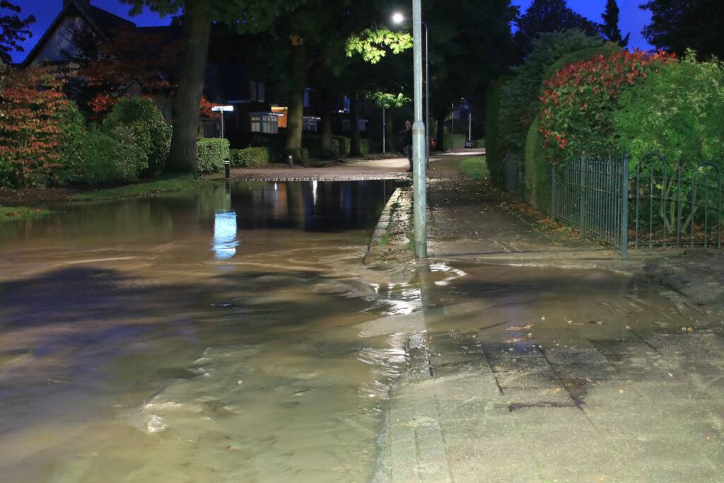 Straat blank door gesprongen waterleiding