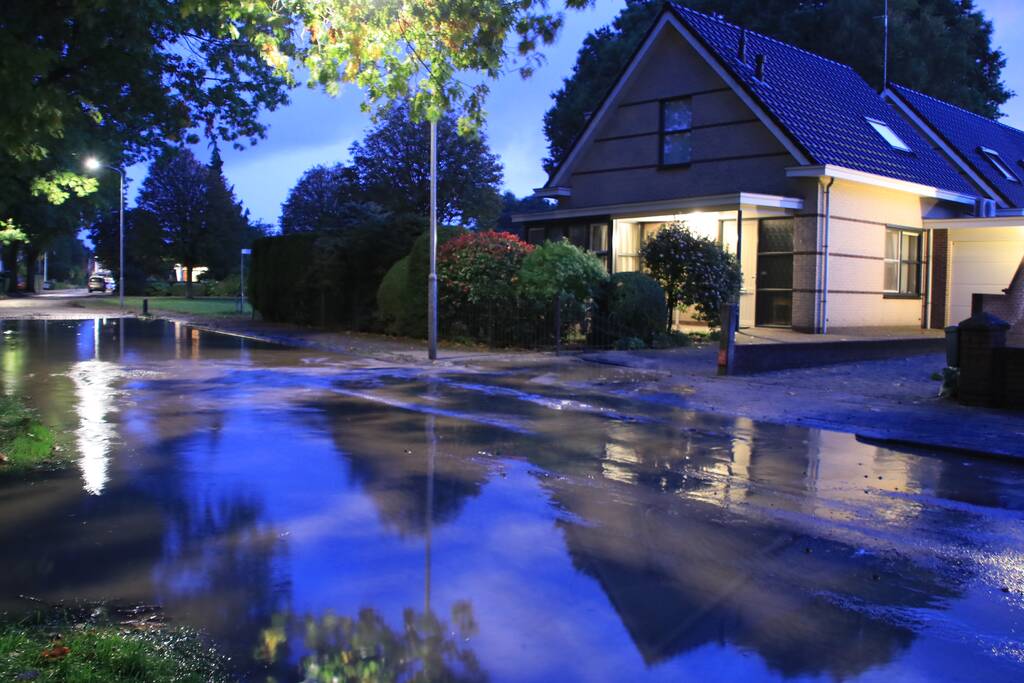Straat blank door gesprongen waterleiding