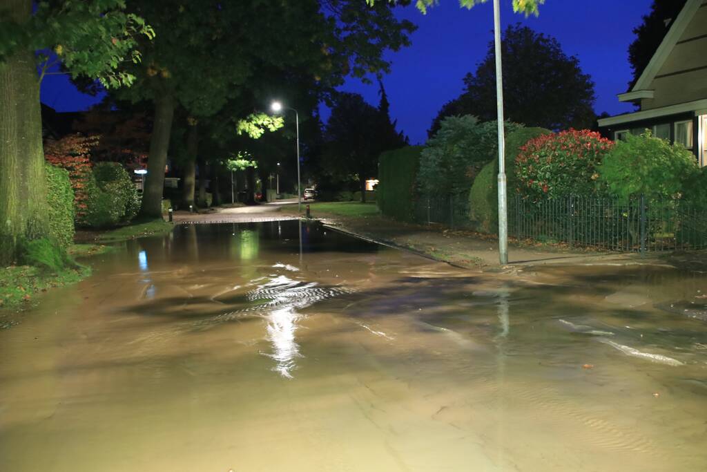 Straat blank door gesprongen waterleiding