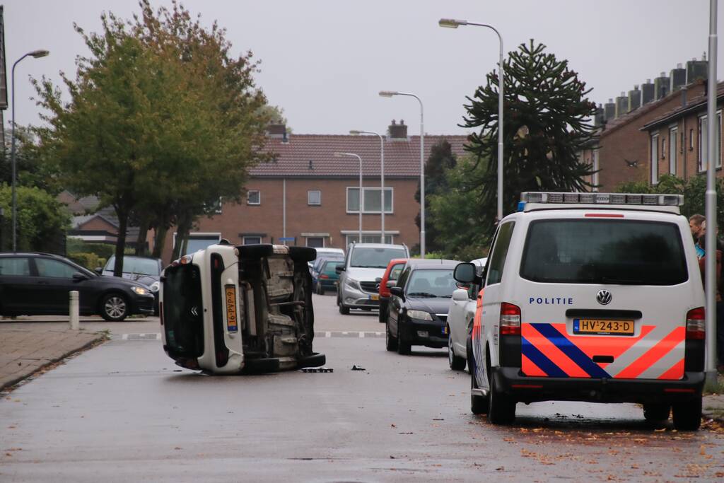 Auto belandt op zijn kant na aanrijding in woonwijk
