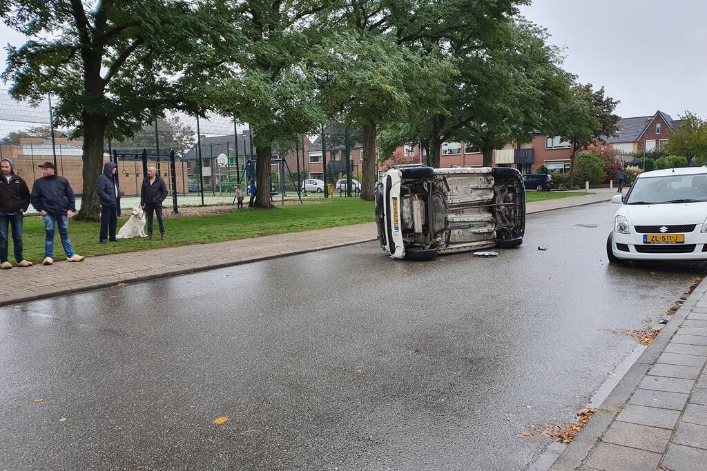 Auto belandt op zijn kant na aanrijding in woonwijk
