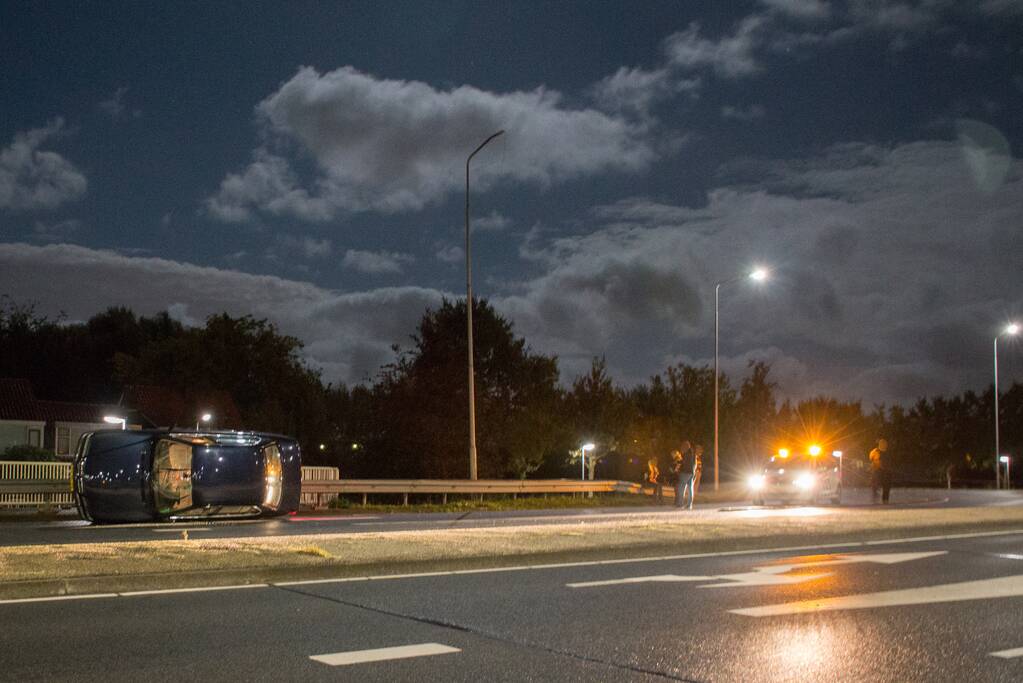 Auto op z'n kant op rotonde