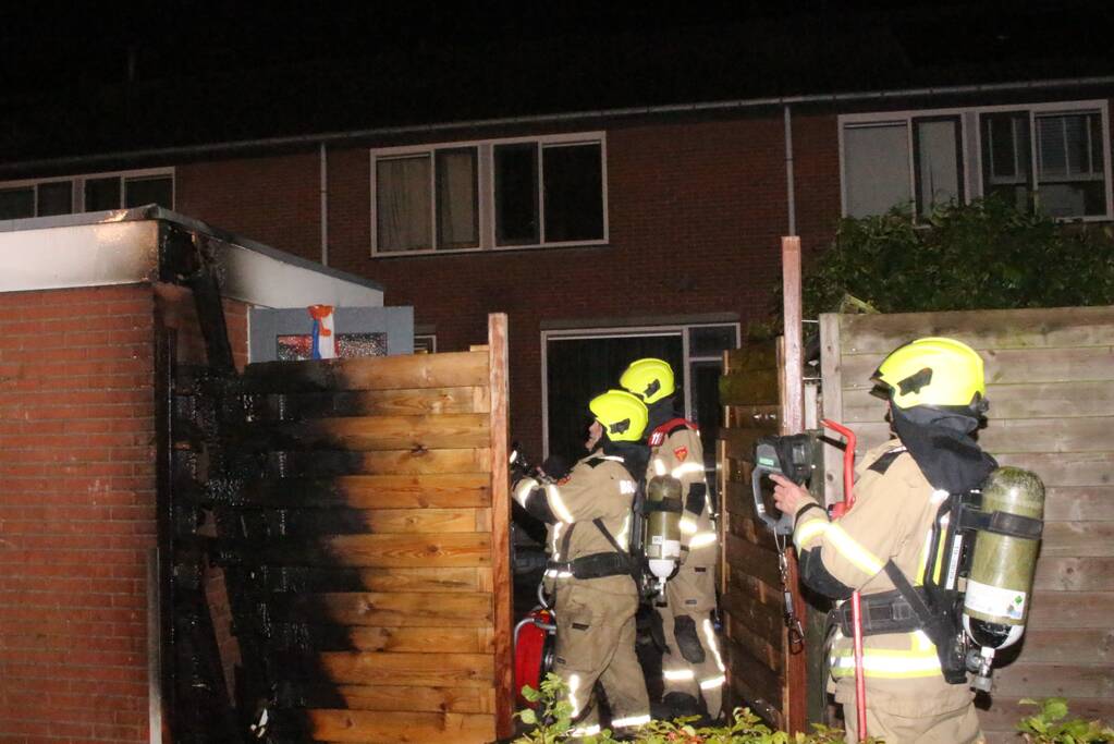 Auto met vloeistof besmeurd, schutting in brand gestoken