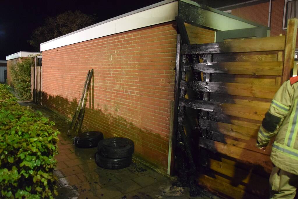 Auto met vloeistof besmeurd, schutting in brand gestoken