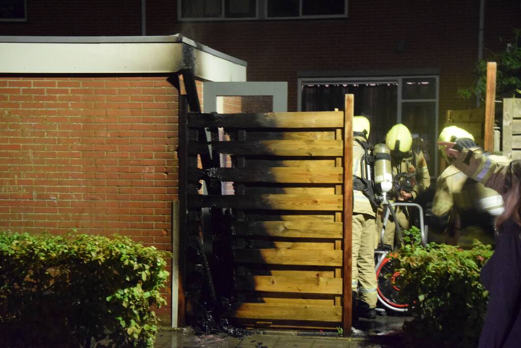 Auto met vloeistof besmeurd, schutting in brand gestoken