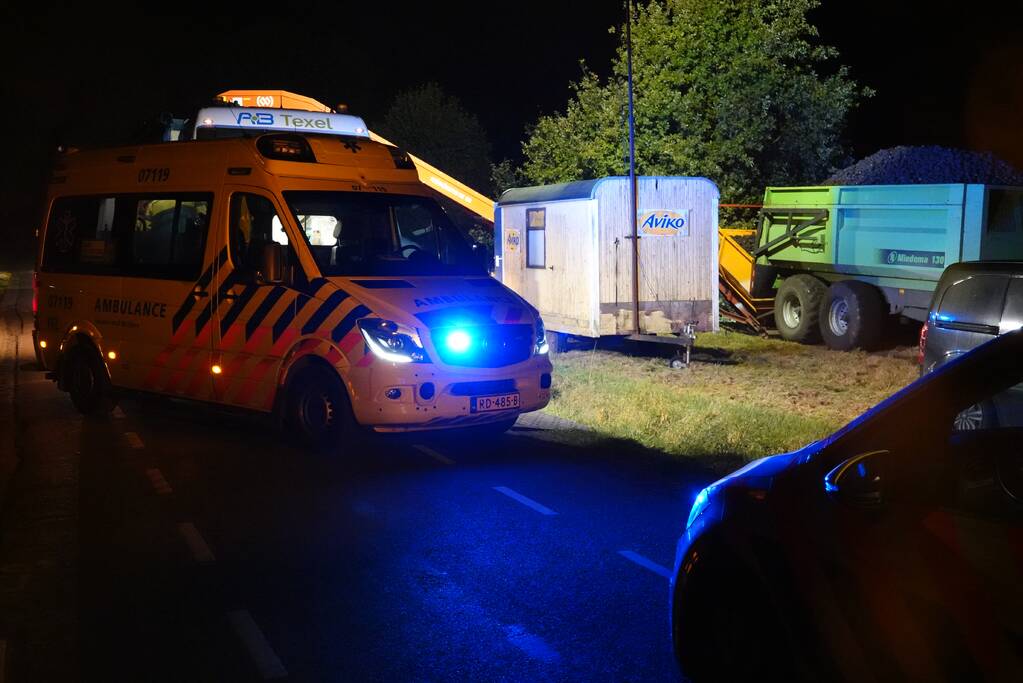 Persoon met hand bekneld in landbouwmachine