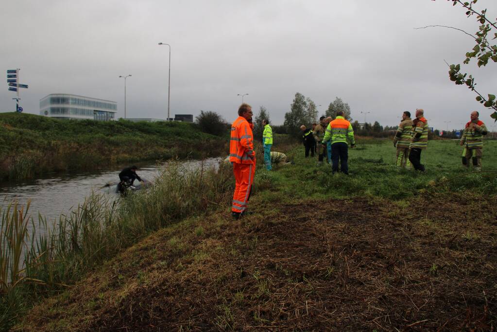 Bestuurder klimt op dak van te water geraakte auto