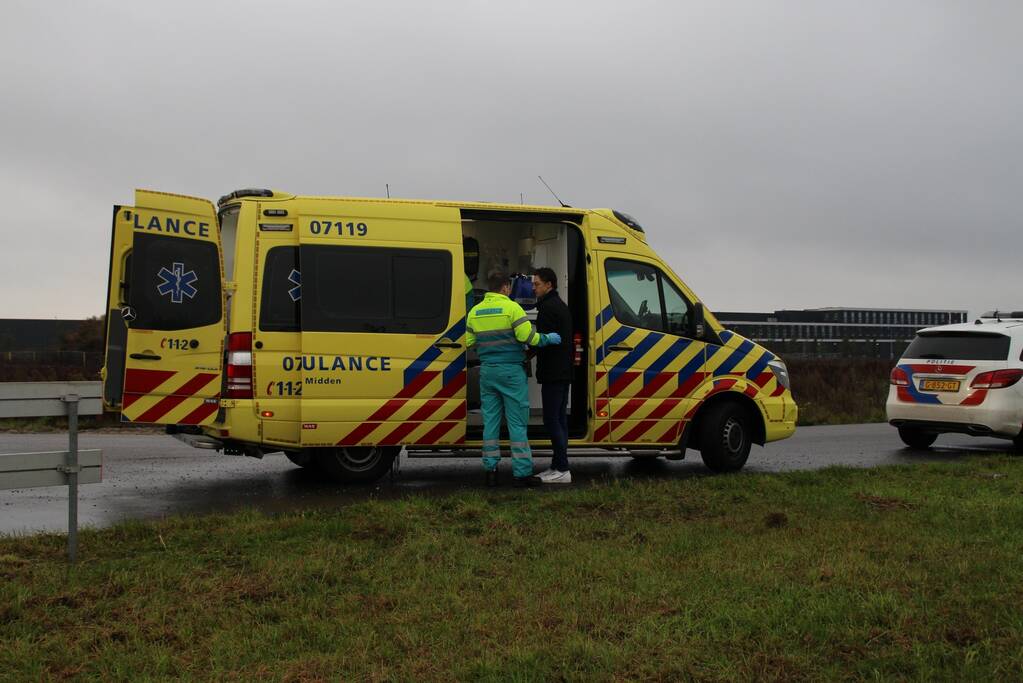 Bestuurder klimt op dak van te water geraakte auto