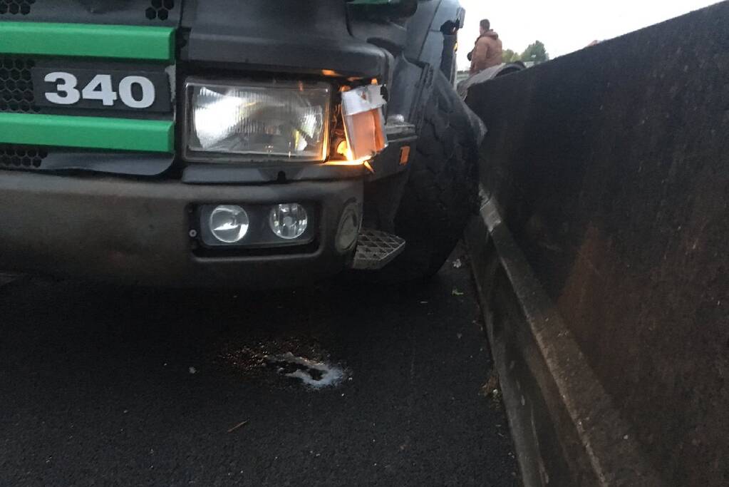 Vrachtwagen botst tegen betonnen geleiderail