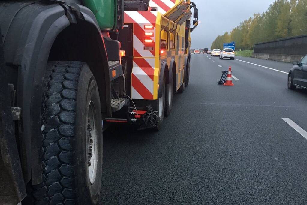 Vrachtwagen botst tegen betonnen geleiderail