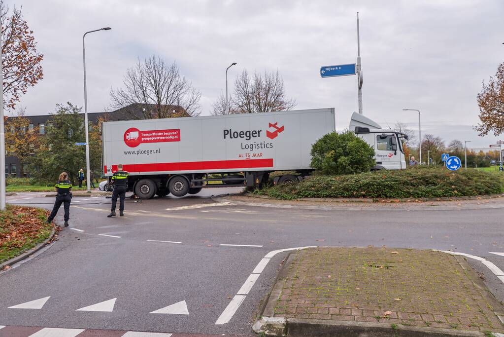 Auto en vrachtwagen botsen op rotonde