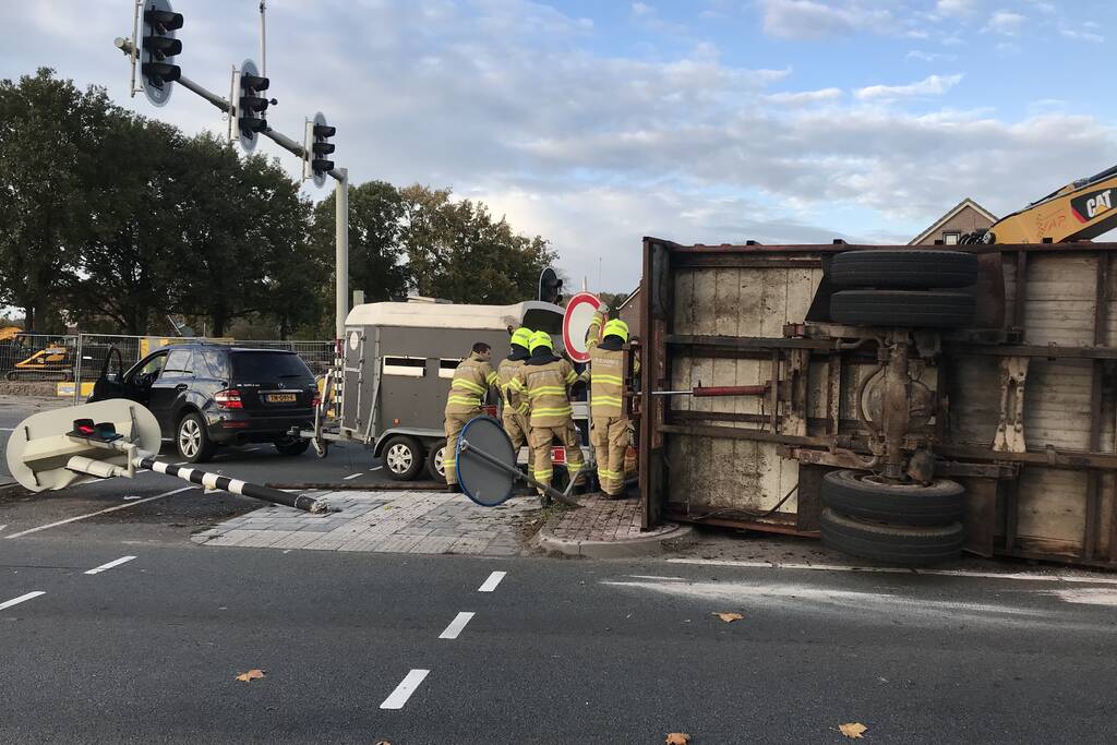 Trailer van tractor met koeien kantelt