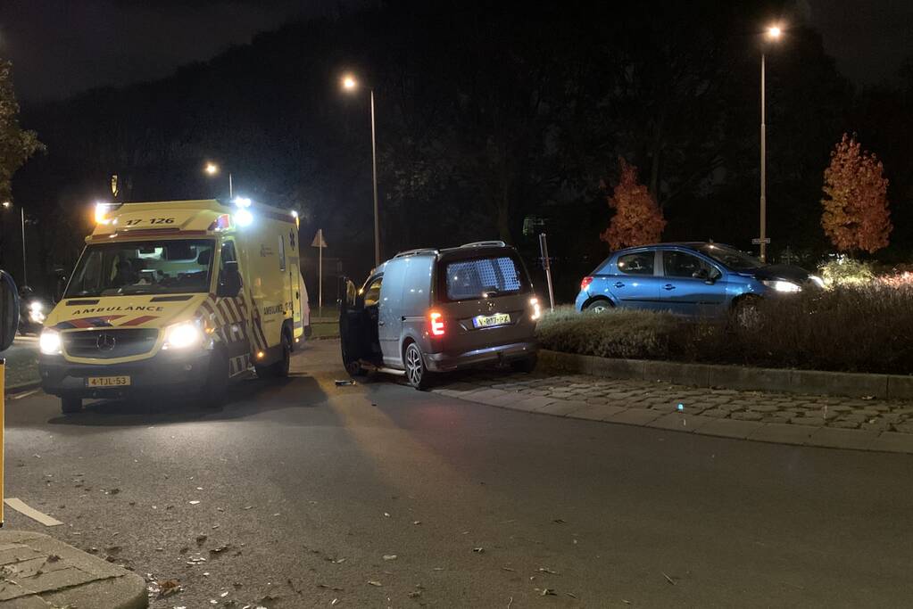 Auto belandt bovenop bosjes op rotonde