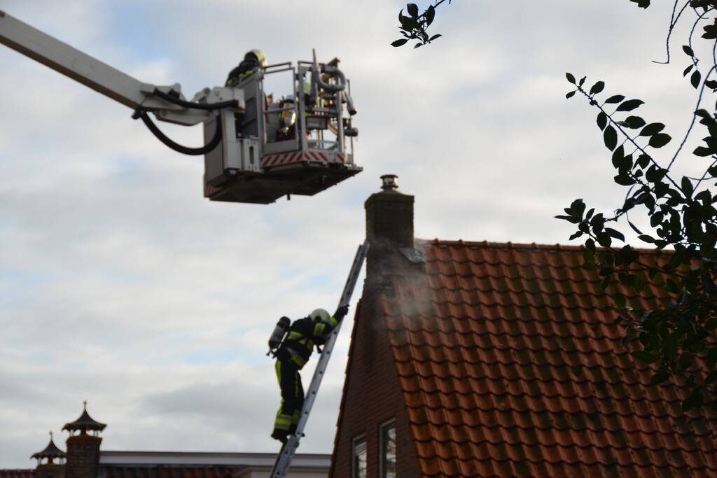 Brand in schoorsteen slaat door na dak