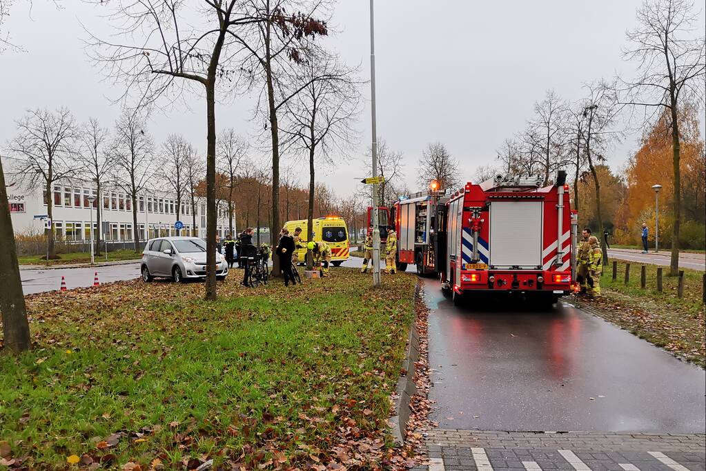 Fietser bekneld onder auto