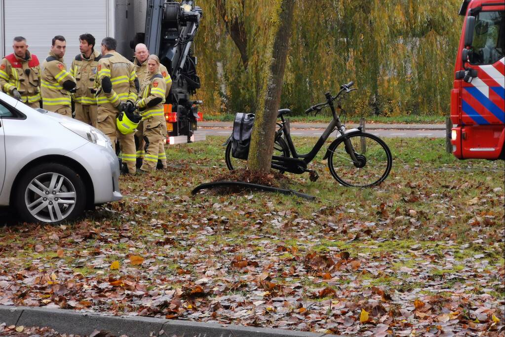 Fietser bekneld onder auto