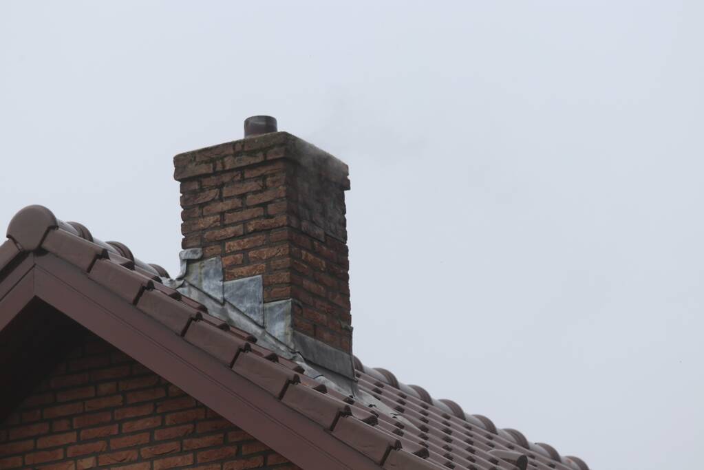 Brandweer veegt schoorsteen na brand