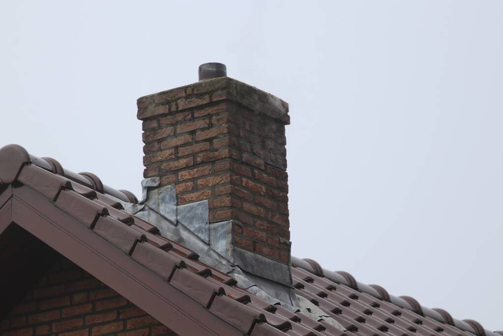 Brandweer veegt schoorsteen na brand