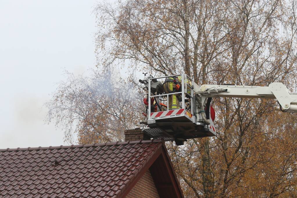 Brandweer veegt schoorsteen na brand
