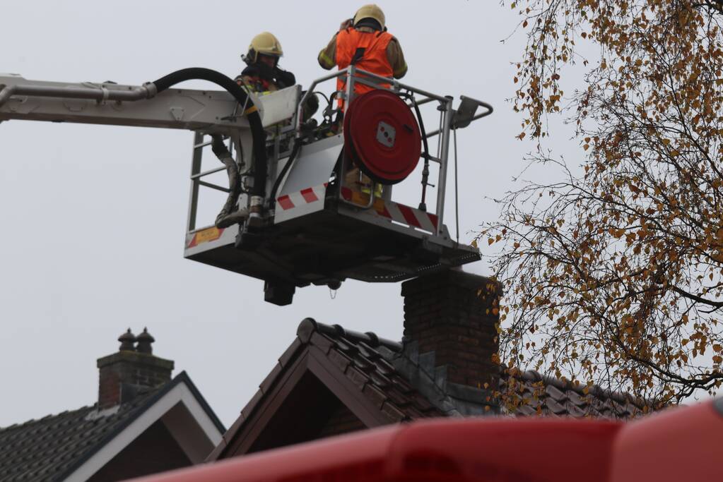 Brandweer veegt schoorsteen na brand