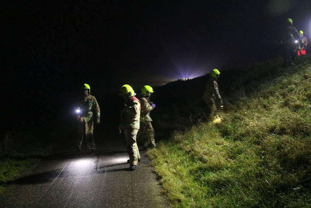 Auto raakt van dijk, brandweer doorzoekt sloot