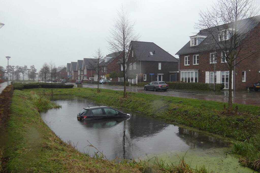 Auto achteruit de sloot in