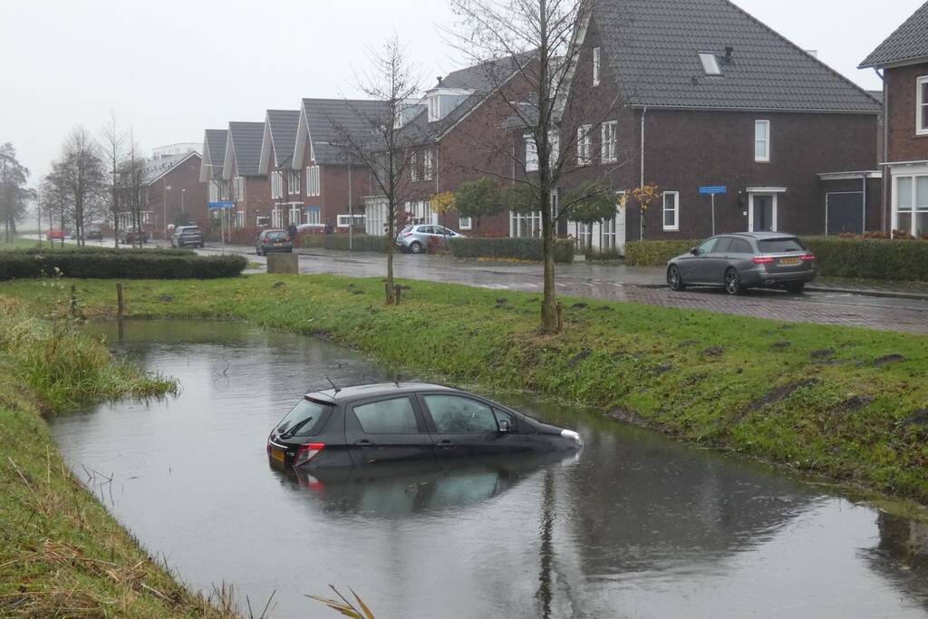 Auto achteruit de sloot in