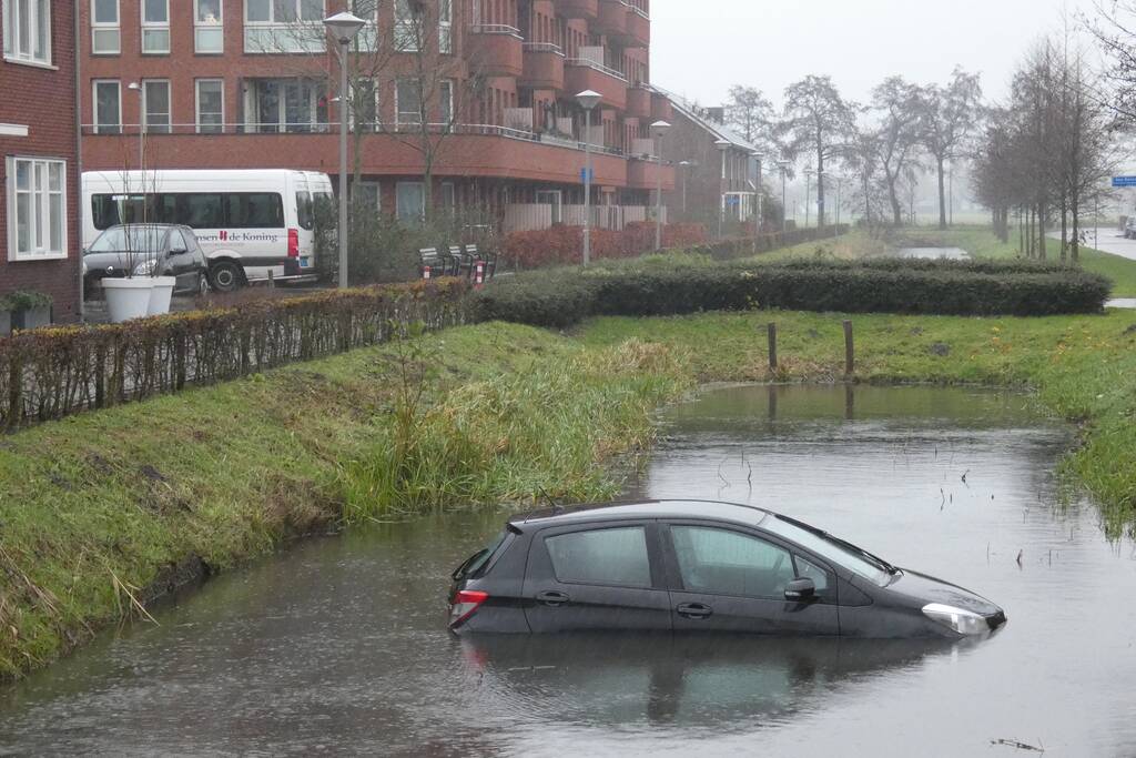 Auto achteruit de sloot in