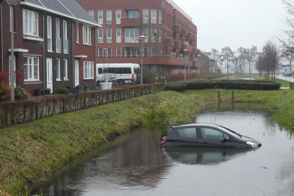 Auto achteruit de sloot in