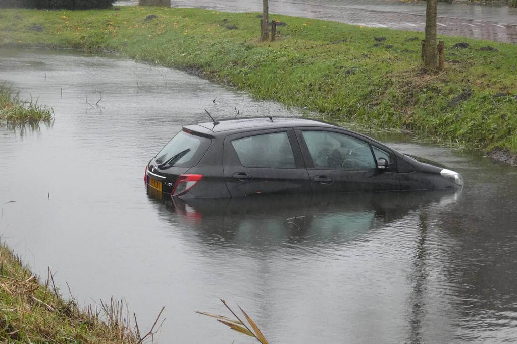 Auto achteruit de sloot in