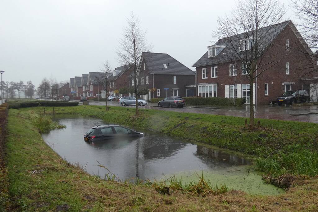 Auto achteruit de sloot in