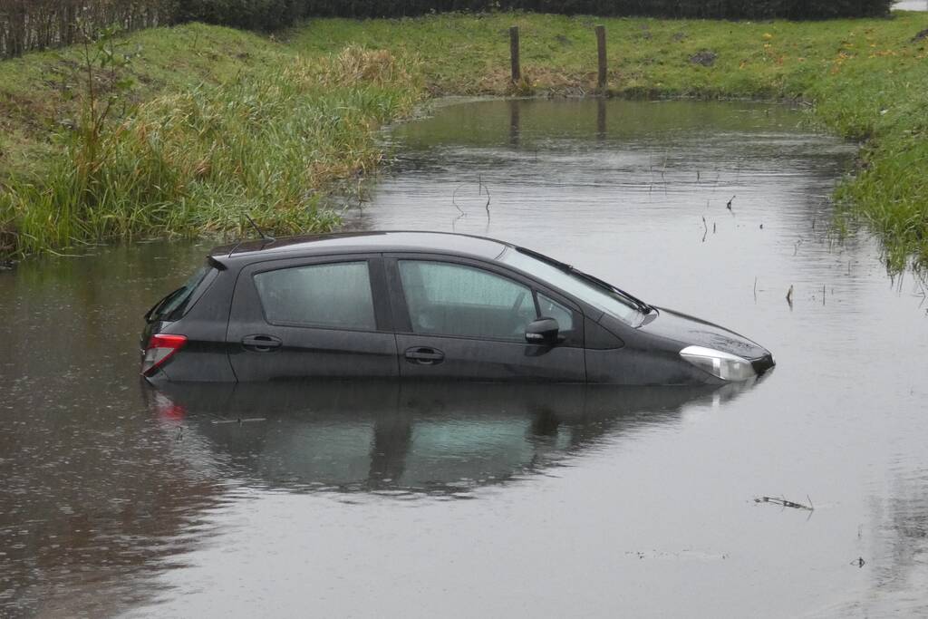 Auto achteruit de sloot in