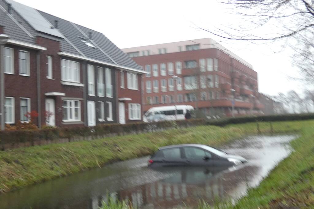 Auto achteruit de sloot in