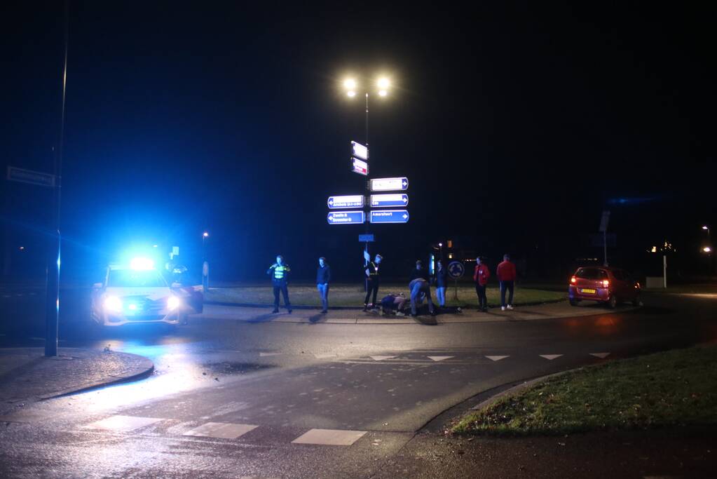 Fietser geschept door auto op rotonde