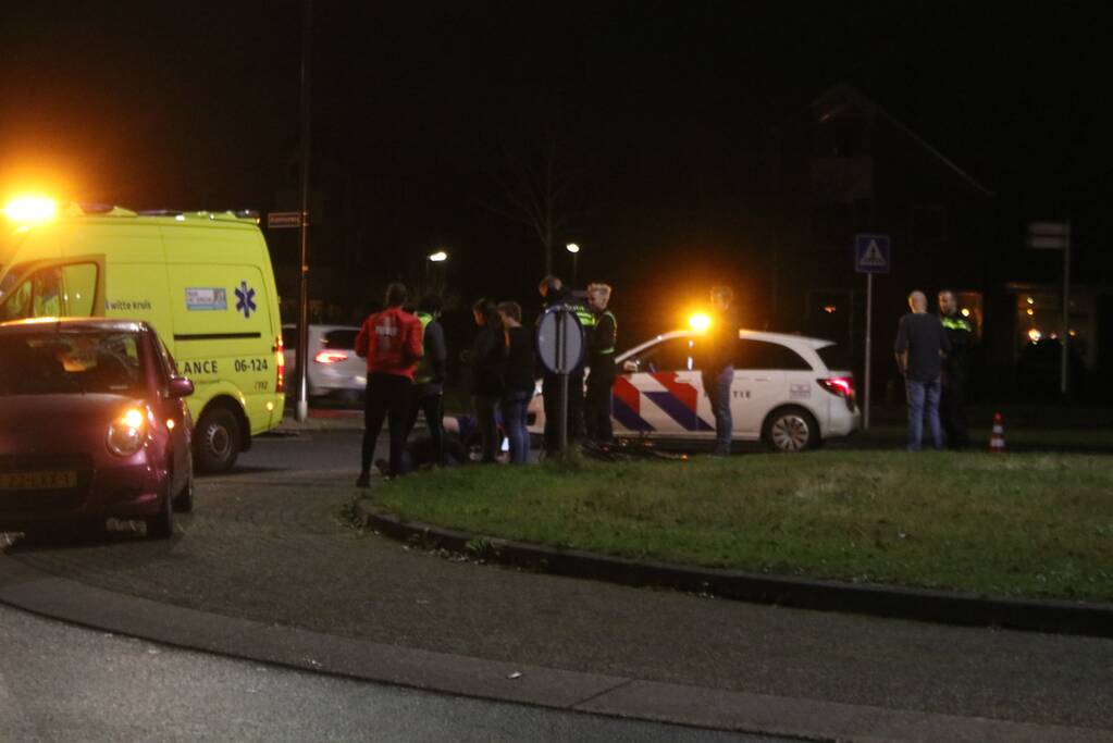 Fietser geschept door auto op rotonde