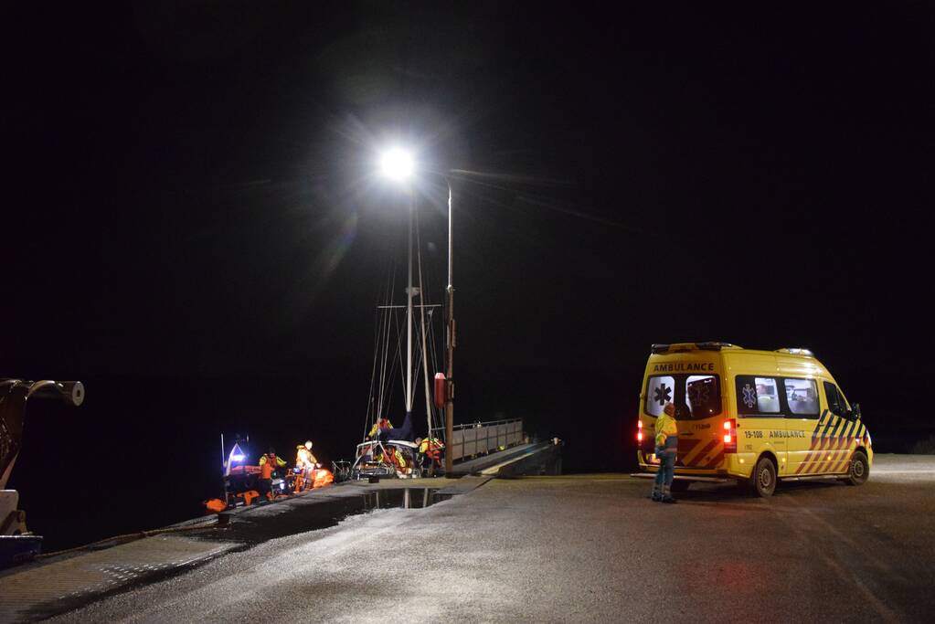 Man valt van zeilboot en belt met smartwatch hulpdiensten