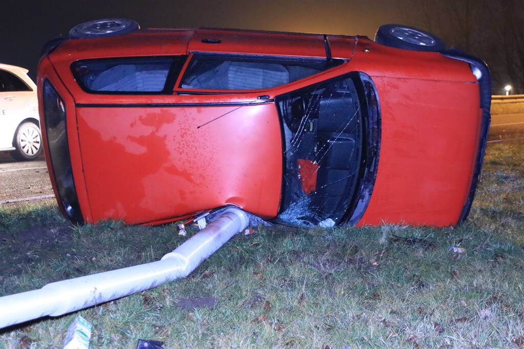 Auto op zijn kant, bestuurder gewond