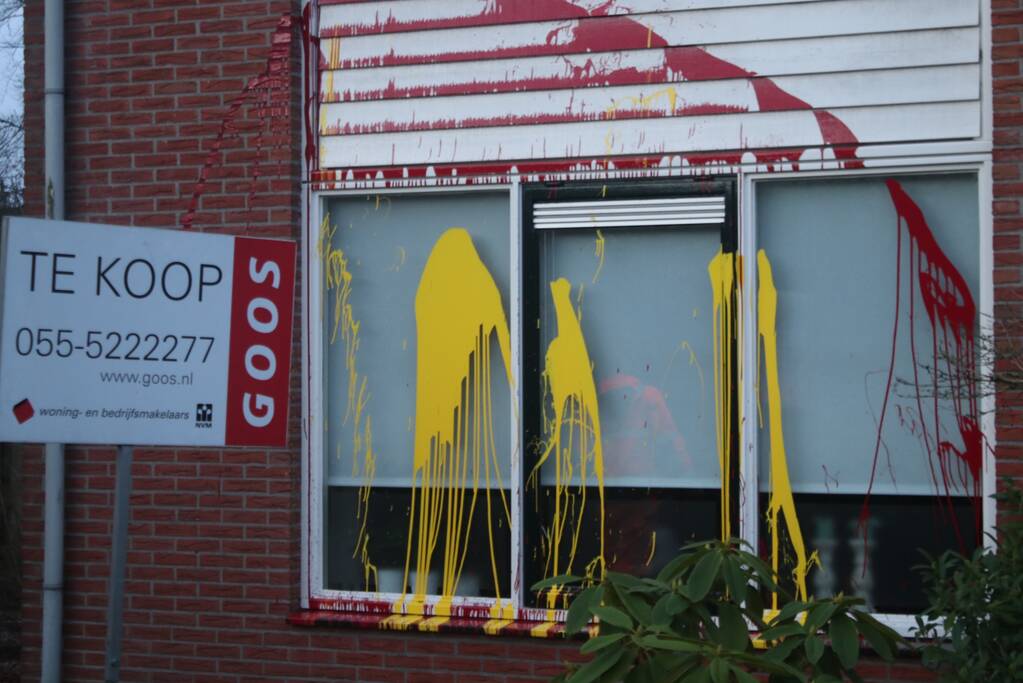 Huis besmeurd met rood en gele verf