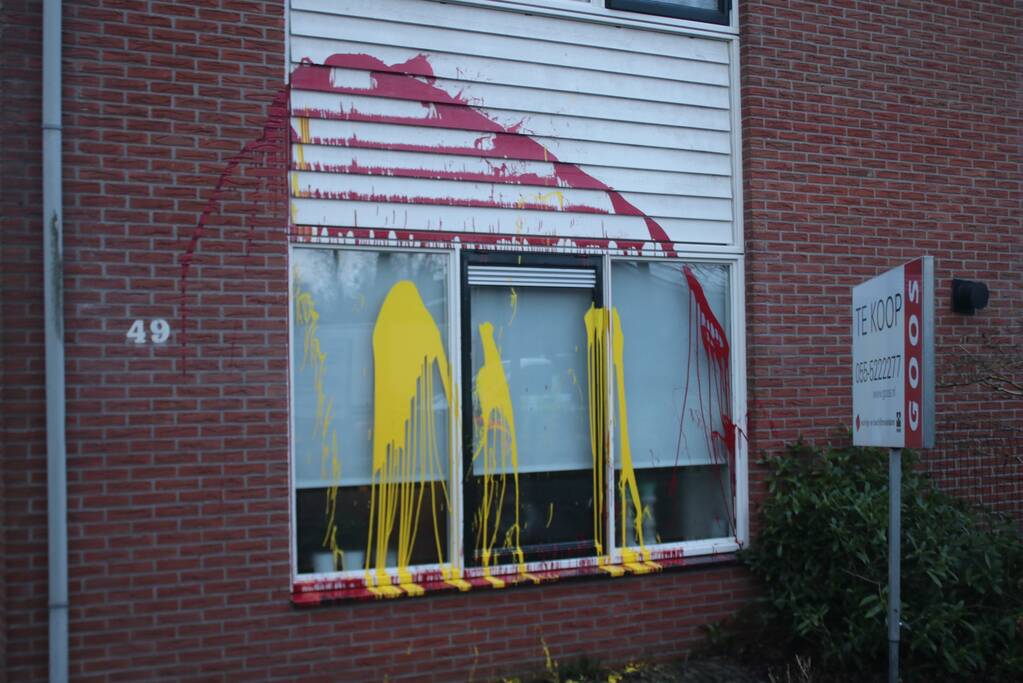 Huis besmeurd met rood en gele verf