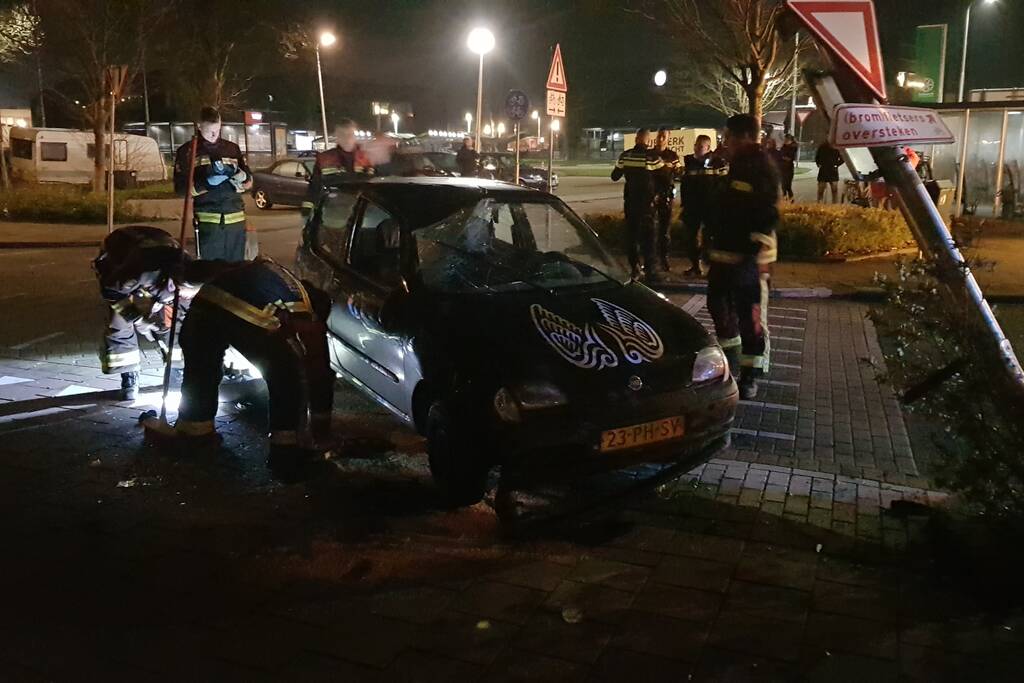 Auto op zijn kant na botsing met lantaarnpaal