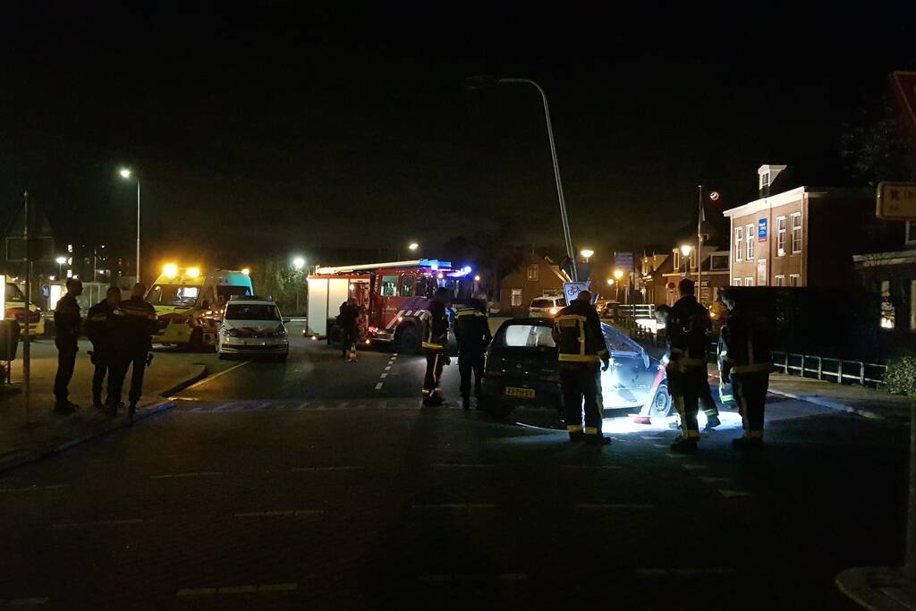 Auto op zijn kant na botsing met lantaarnpaal