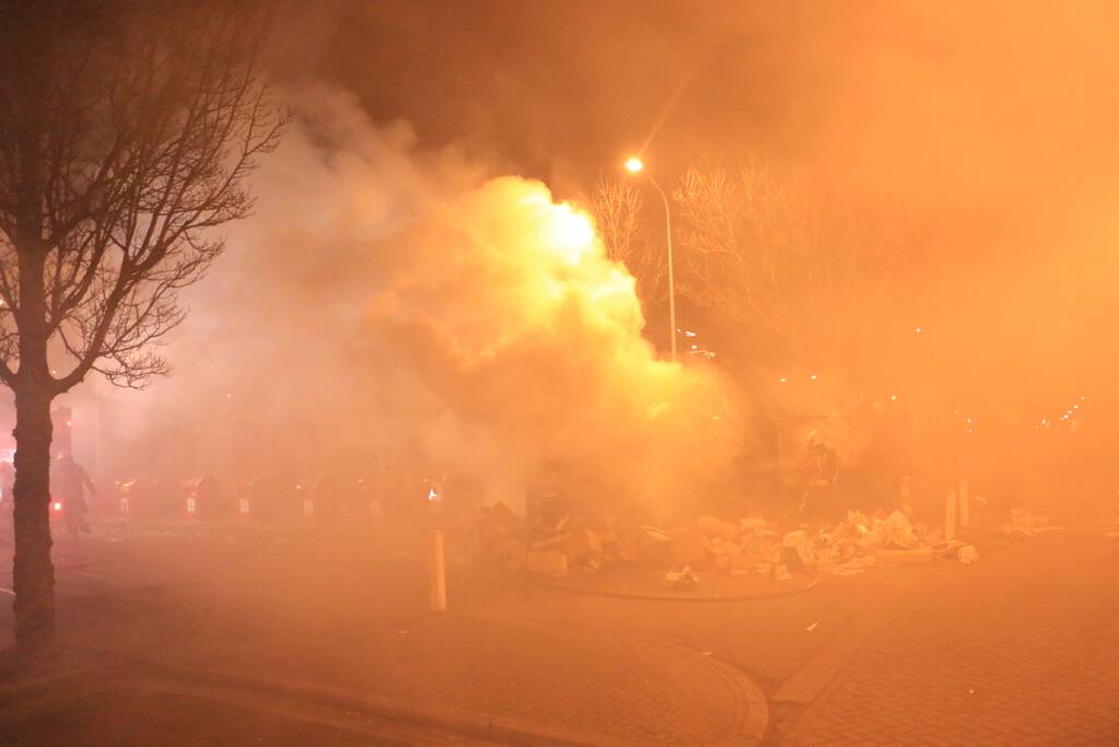 Brandweer druk met brand in container vol karton