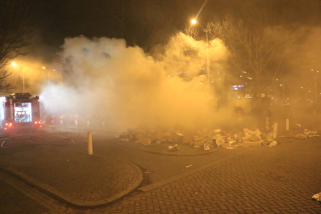 Brandweer druk met brand in container vol karton