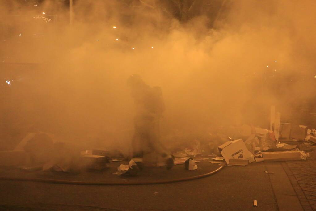 Brandweer druk met brand in container vol karton