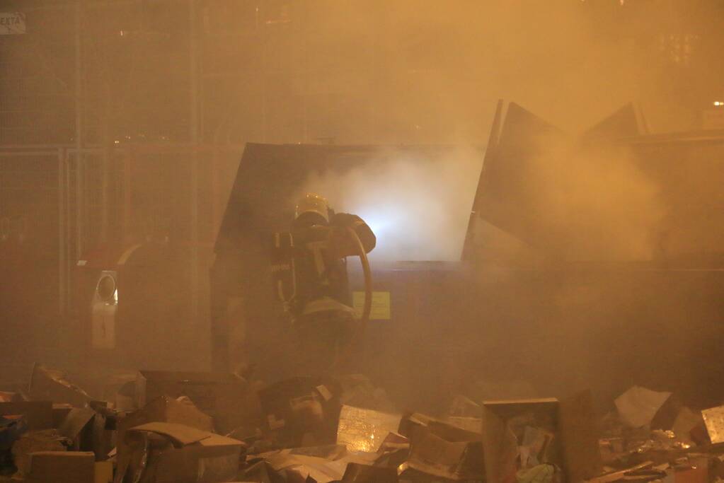 Brandweer druk met brand in container vol karton