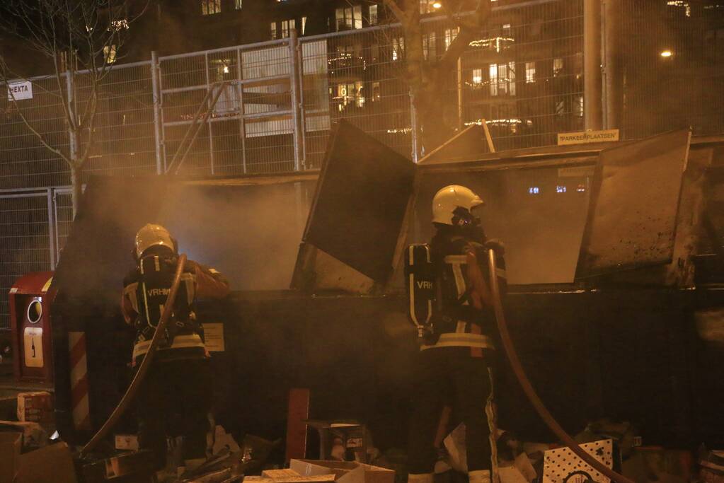 Brandweer druk met brand in container vol karton