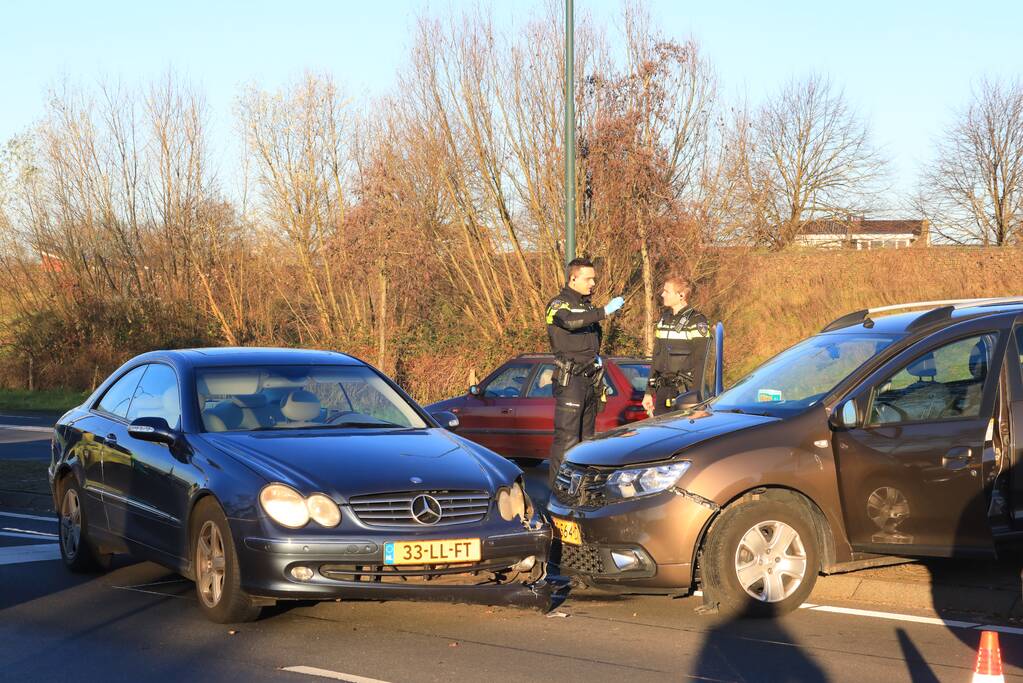 Twee personenauto's botsen op elkaar op rotonde