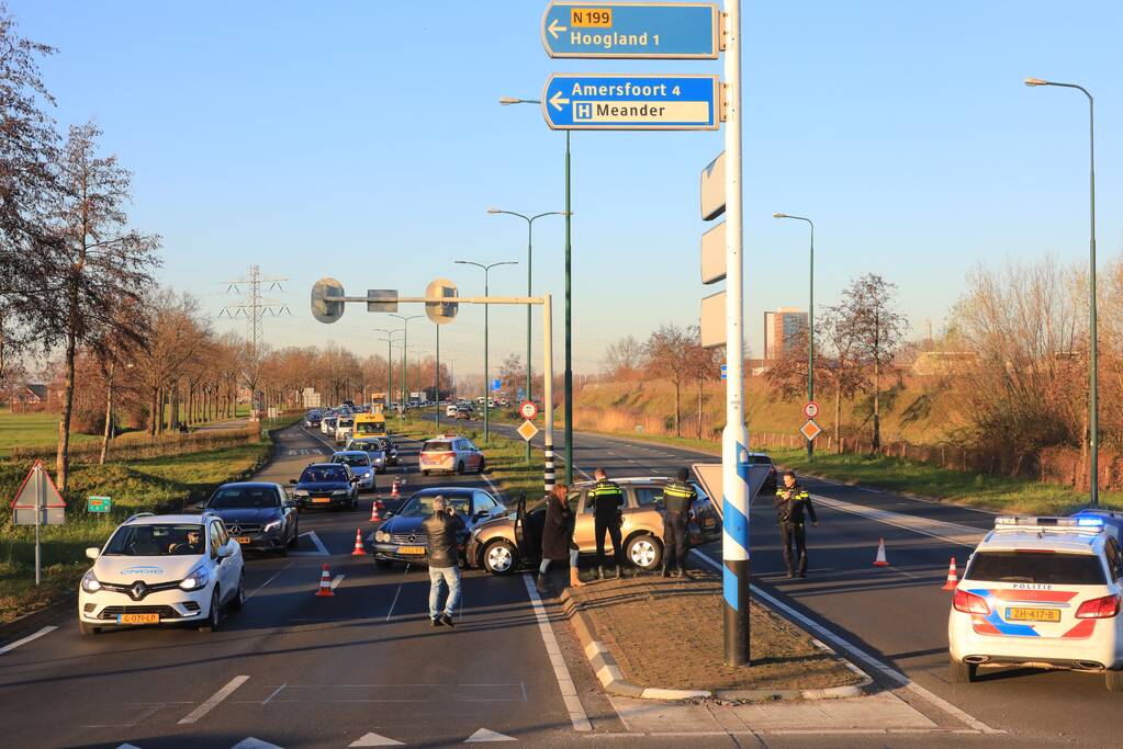 Twee personenauto's botsen op elkaar op rotonde