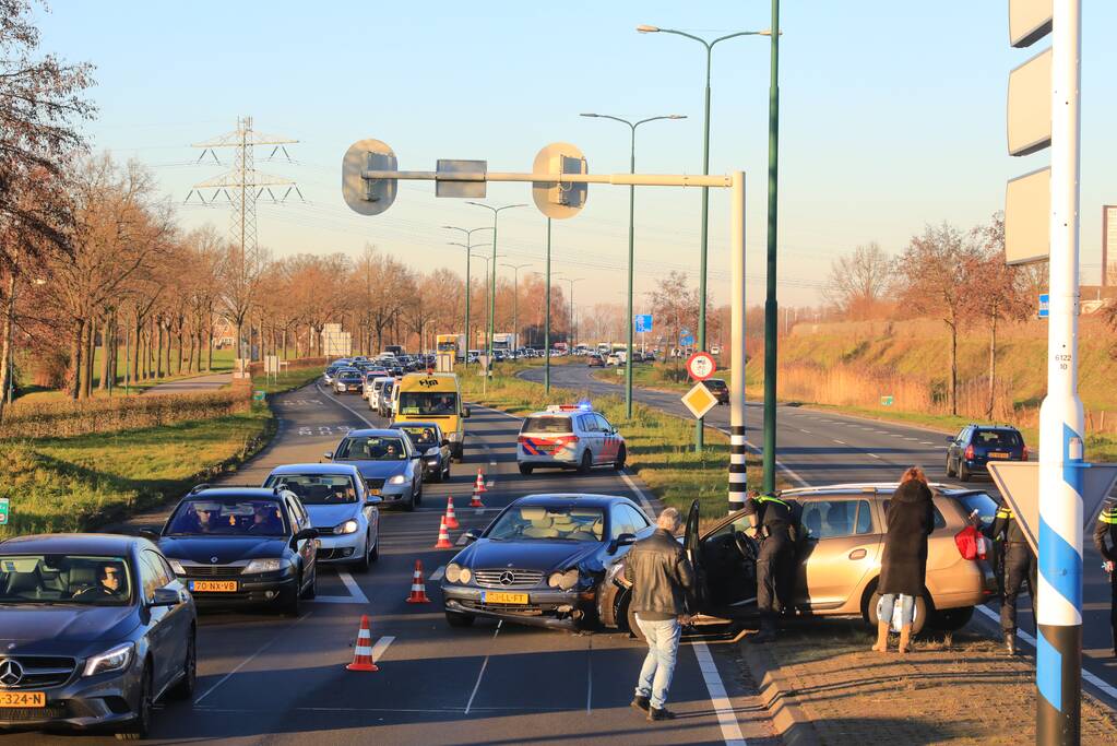 Twee personenauto's botsen op elkaar op rotonde