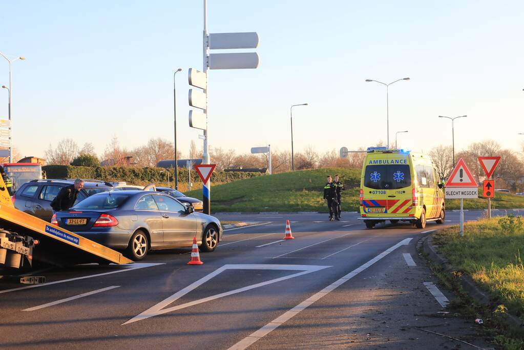 Twee personenauto's botsen op elkaar op rotonde